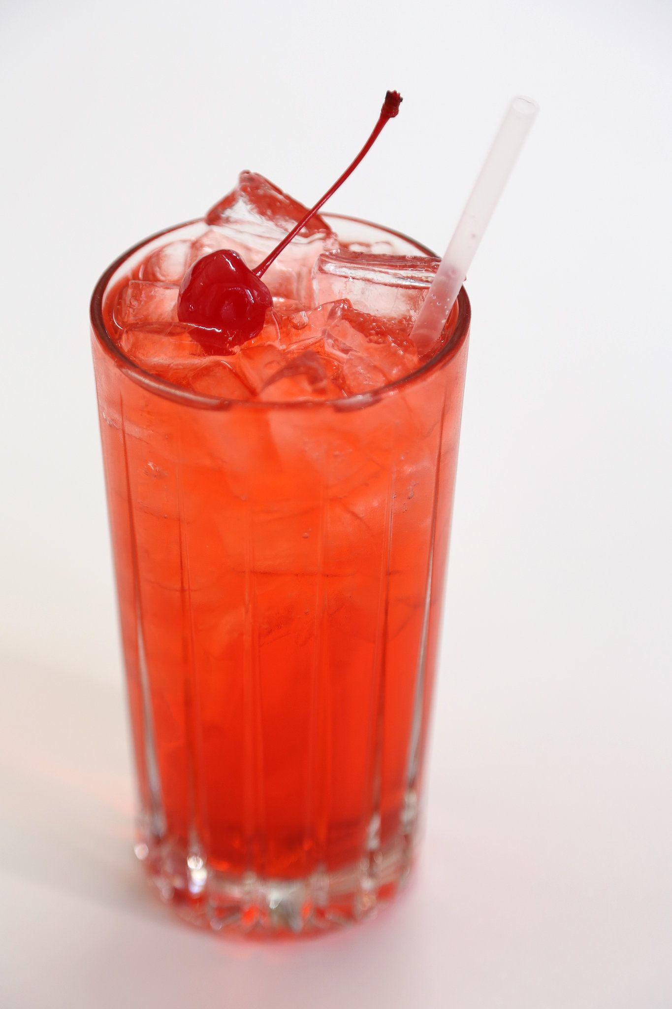 Cocktail Shirley Temple – boisson pétillante sans alcool à base de limonade, grenadine et cerise confite, servi avec gaieté dans un verre transparent, symbole de douceur et de convivialité.