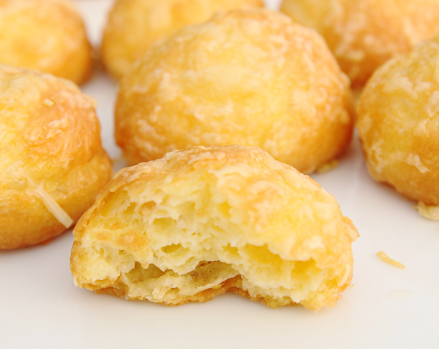 Gougères – bouchées dorées et aérées à base de pâte à choux et fromage, servies tièdes pour une expérience gourmande et conviviale au bar.